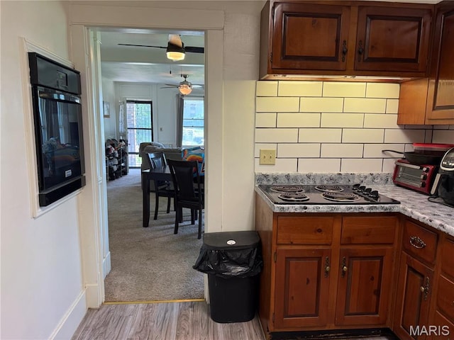 111 N Levering Ave, Hannibal, MO 63401 - kitchen with electric stovetop, a ceiling fan, oven, backsplash, and baseboards