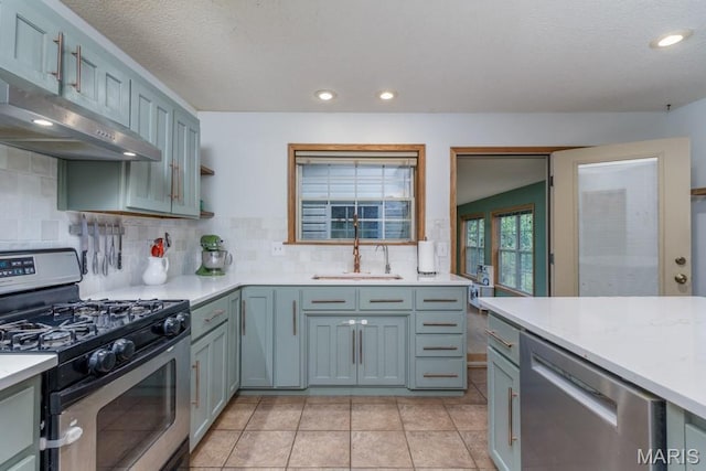 25350 Englewood Ln, Lebanon, MO 65536 - kitchen featuring appliances with stainless steel finishes, under cabinet range hood, light countertops, backsplash, and recessed lighting
