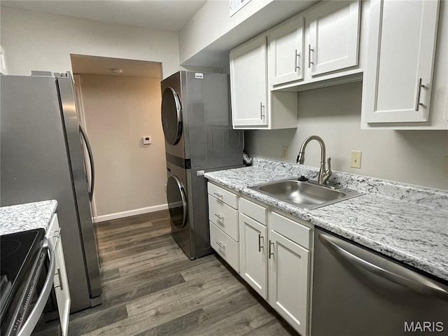 9158 Eager Rd, Brentwood, MO 63144 - kitchen featuring appliances with stainless steel finishes, stacked washer and clothes dryer, dark wood-style floors, and white cabinets