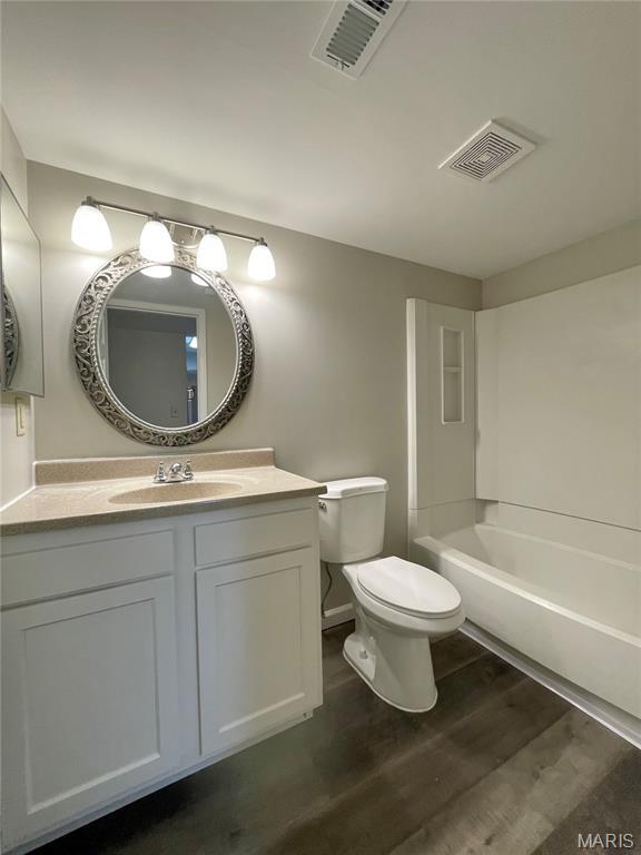 9158 Eager Rd, Brentwood, MO 63144 - bathroom with a tub, vanity, and wood finished floors