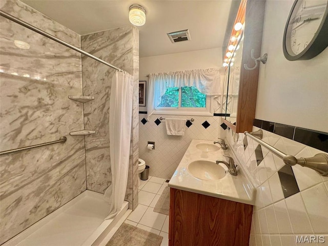 115 Park St, Monroe City, MO 63456 - full bath featuring tile patterned floors, tile walls, a stall shower, a wainscoted wall, and double vanity