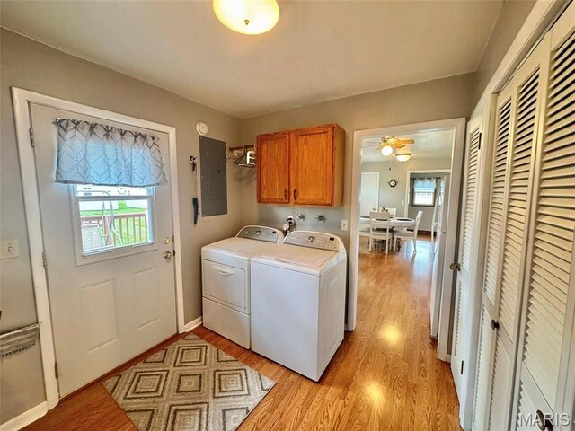 115 Park St, Monroe City, MO 63456 - laundry area featuring cabinet space, electric panel, washing machine and dryer, and light wood-type flooring