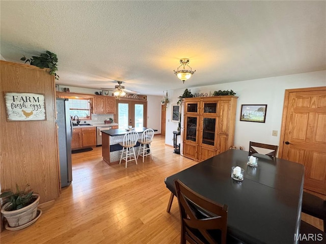 3581 Eagle Crest Dr, Palmyra, MO 63461 - dining room with light wood finished floors, ceiling fan, and a textured ceiling