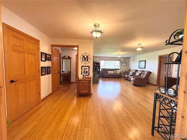 3581 Eagle Crest Dr, Palmyra, MO 63461 - living room featuring a textured ceiling, light wood-style flooring, and baseboards
