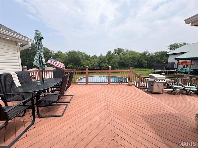 3581 Eagle Crest Dr, Palmyra, MO 63461 - wooden terrace with a trampoline, outdoor dining space, and grilling area