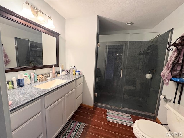 3581 Eagle Crest Dr, Palmyra, MO 63461 - bathroom with vanity, toilet, a stall shower, wood finish floors, and a textured ceiling