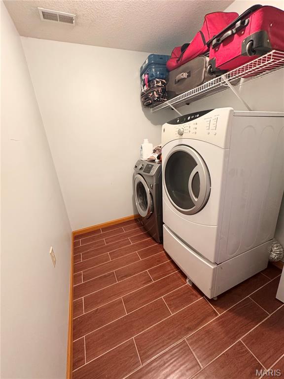 3581 Eagle Crest Dr, Palmyra, MO 63461 - washroom featuring independent washer and dryer, wood tiled floors, a textured ceiling, and baseboards