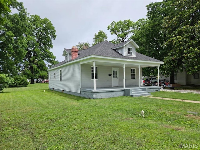 308 E Kathleen, Sikeston, MO 63801 - view of front of house featuring covered porch, a front lawn, roof with shingles, and a chimney