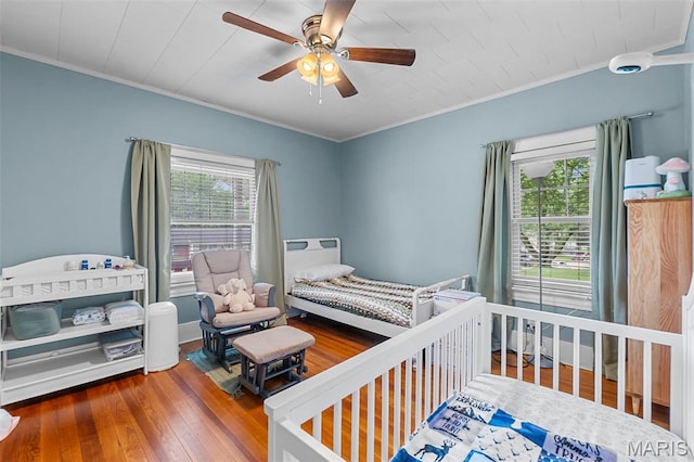 618 Parkview St, Jackson, MO 63755 - bedroom with ornamental molding, hardwood / wood-style flooring, ceiling fan, and a nursery area