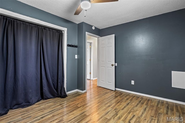 1 Mileva Ct, Farmington, MO 63640 - unfurnished bedroom with wood finished floors, baseboards, a textured ceiling, and a ceiling fan