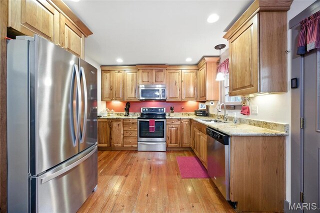 1423 Emily Ln, Festus, MO 63028 - kitchen with appliances with stainless steel finishes, light wood-style flooring, light stone counters, recessed lighting, and pendant lighting
