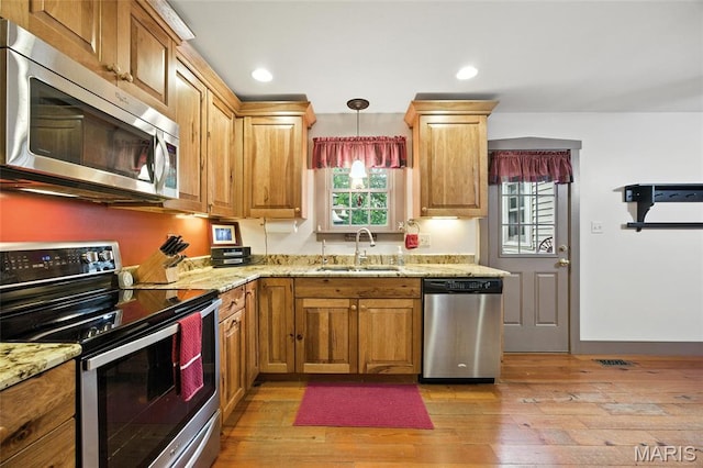 1423 Emily Ln, Festus, MO 63028 - kitchen featuring appliances with stainless steel finishes, light stone counters, light wood finished floors, hanging light fixtures, and recessed lighting