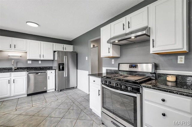 12006 Glengrove Dr, Maryland Heights, MO 63043 - kitchen featuring stainless steel appliances, under cabinet range hood, white cabinetry, and dark stone countertops