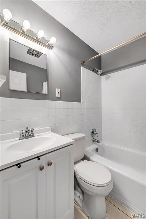 12006 Glengrove Dr, Maryland Heights, MO 63043 - full bathroom with tile walls, vanity,  shower combination, a textured ceiling, and tile patterned flooring