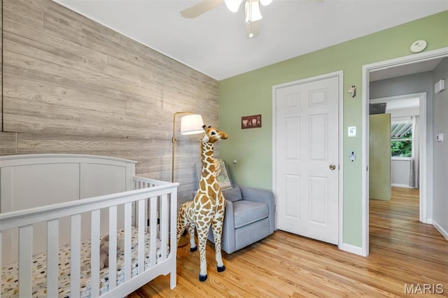 12006 Glengrove Dr, Maryland Heights, MO 63043 - bedroom featuring wood finished floors, an accent wall, a ceiling fan, and wooden walls