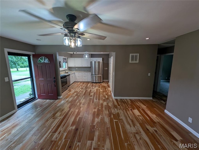 326 S Elm St, Bethalto, IL 62010 - kitchen with stainless steel appliances, white cabinetry, baseboards, light wood-style floors, and a ceiling fan