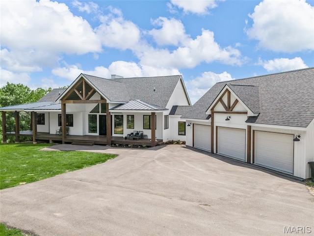 22206 Tree Farm Rd, Hermann, MO 63383 - modern farmhouse with asphalt driveway, an attached garage, roof with shingles, a front yard, and covered porch