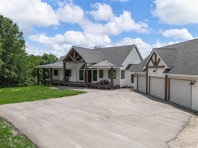 22206 Tree Farm Rd, Hermann, MO 63383 - modern farmhouse with driveway, an attached garage, roof with shingles, a porch, and a front yard