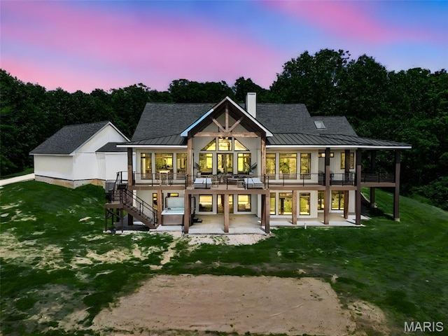 22206 Tree Farm Rd, Hermann, MO 63383 - back of house at dusk featuring a standing seam roof, stairs, a patio area, and metal roof