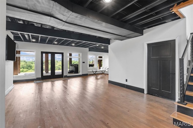 22206 Tree Farm Rd, Hermann, MO 63383 - unfurnished living room featuring stairs, wood finished floors, baseboards, french doors, and beam ceiling