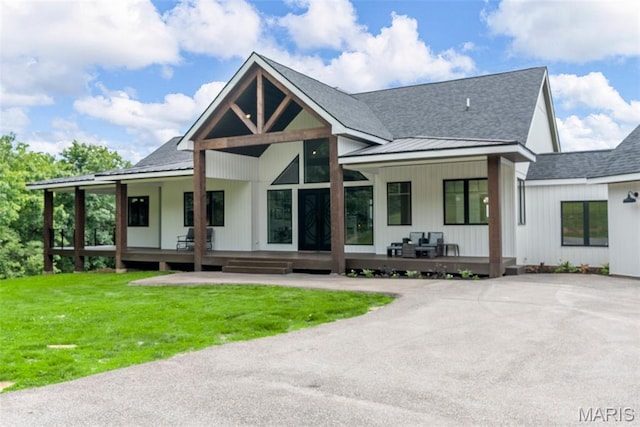 22206 Tree Farm Rd, Hermann, MO 63383 - rear view of property with a porch, roof with shingles, a yard, and a standing seam roof