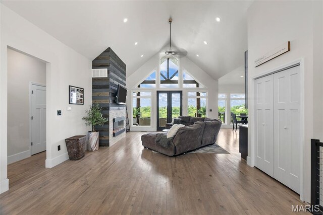 22206 Tree Farm Rd, Hermann, MO 63383 - living area with high vaulted ceiling, a fireplace, a ceiling fan, baseboards, and wood finished floors