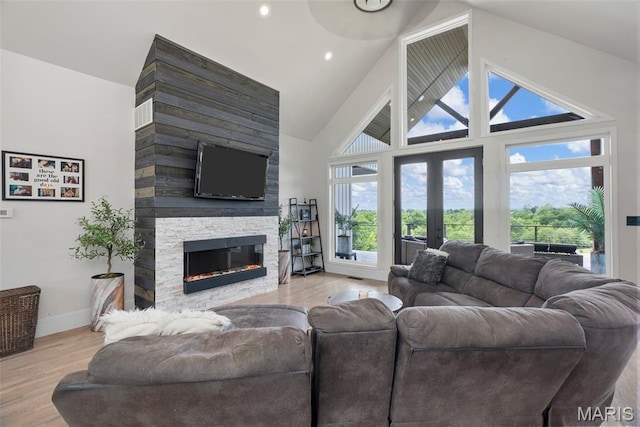 22206 Tree Farm Rd, Hermann, MO 63383 - living area featuring a stone fireplace, french doors, wood finished floors, baseboards, and high vaulted ceiling
