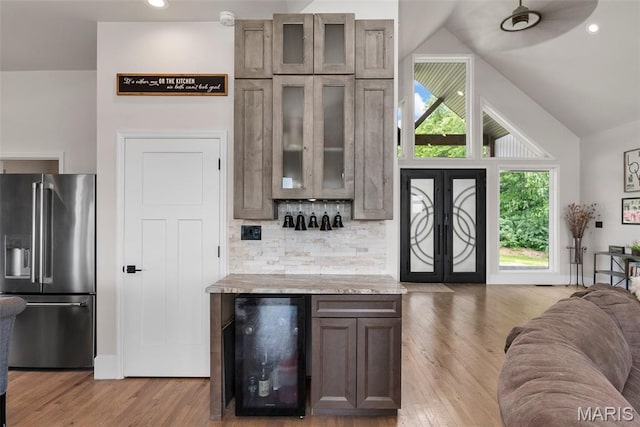 22206 Tree Farm Rd, Hermann, MO 63383 - bar featuring high end refrigerator, wine cooler, light wood-style floors, lofted ceiling, and decorative backsplash