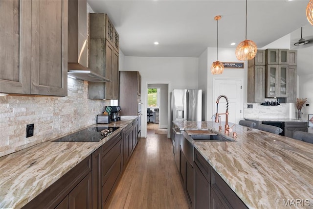 22206 Tree Farm Rd, Hermann, MO 63383 - kitchen featuring wall chimney range hood, a sink, black electric stovetop, light stone counters, and recessed lighting