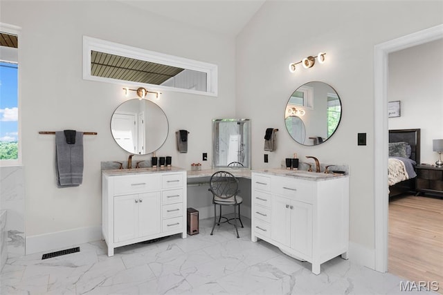 22206 Tree Farm Rd, Hermann, MO 63383 - bathroom featuring marble finish flooring, baseboards, two vanities, and ensuite bath