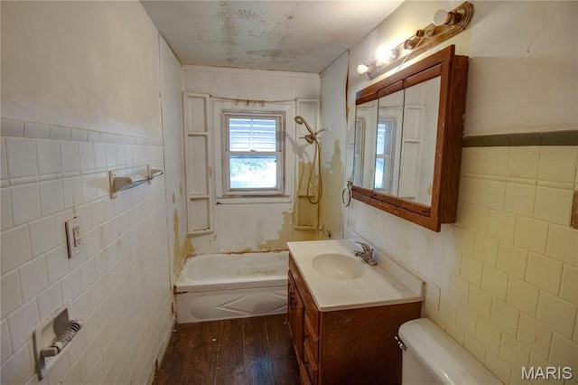33974 Irish Ln, Brighton, IL 62012 - bathroom featuring tile walls, vanity, wood finished floors, bathtub / shower combination, and wainscoting