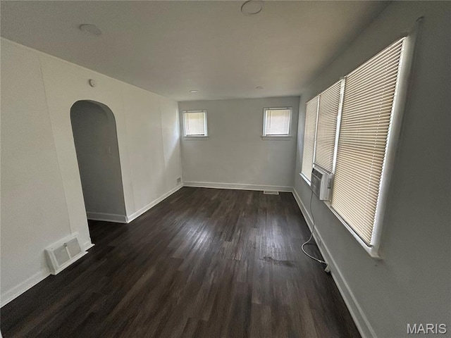 8937 Edna St, Saint Louis, MO 63147 - unfurnished room with dark wood finished floors, arched walkways, and baseboards