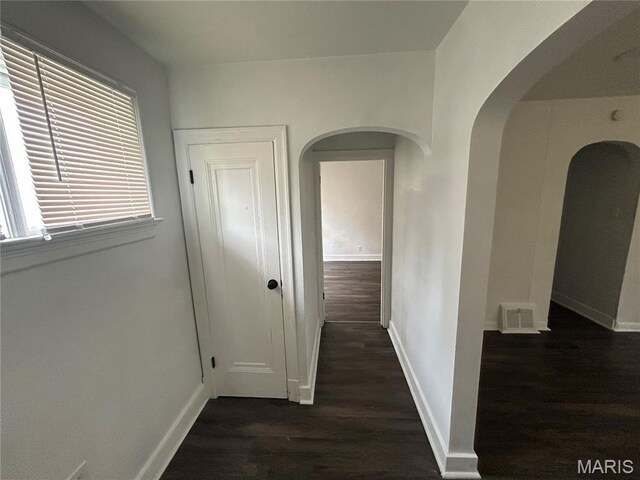 8937 Edna St, Saint Louis, MO 63147 - hall featuring arched walkways, dark wood-style flooring, and baseboards
