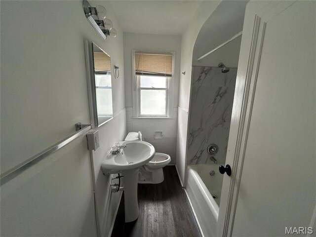 8937 Edna St, Saint Louis, MO 63147 - bathroom featuring wood finished floors, bathtub / shower combination, toilet, and a sink