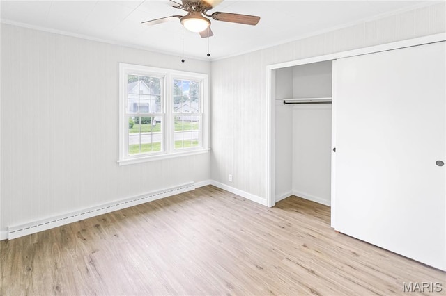 420 E Hauser St, Litchfield, IL 62056 - unfurnished bedroom with baseboard heating, ornamental molding, wood finished floors, a closet, and baseboards