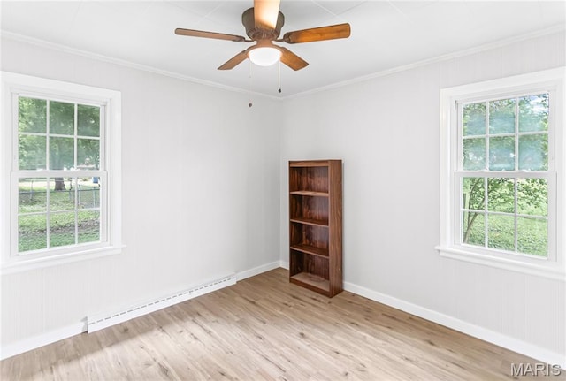 420 E Hauser St, Litchfield, IL 62056 - spare room featuring baseboard heating, plenty of natural light, light wood finished floors, and crown molding