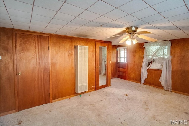 33425 Irish Ln, Brighton, IL 62012 - empty room with a heating unit, wooden walls, ceiling fan, and carpet flooring