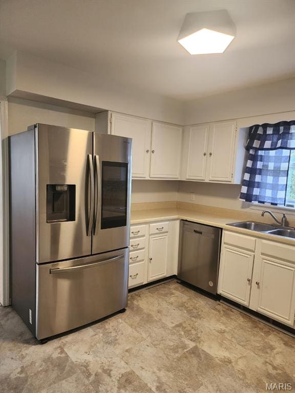 108 Auburn Dr, Waynesville, MO 65583 - kitchen featuring appliances with stainless steel finishes, a sink, white cabinets, light countertops, and stone finish floors