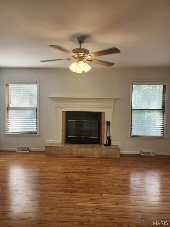 108 Auburn Dr, Waynesville, MO 65583 - unfurnished living room featuring wood finished floors, ceiling fan, a tiled fireplace, and baseboards