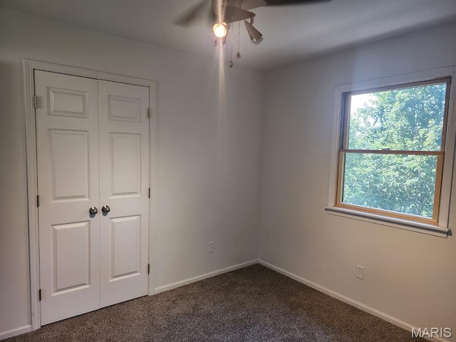 108 Auburn Dr, Waynesville, MO 65583 - unfurnished bedroom with dark carpet, baseboards, a closet, and a ceiling fan