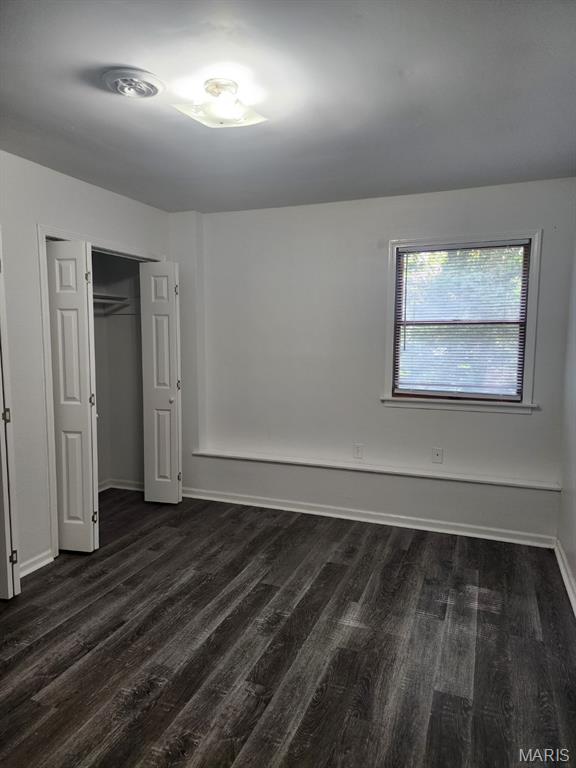 108 Auburn Dr, Waynesville, MO 65583 - unfurnished bedroom with dark wood-style floors, baseboards, and a closet