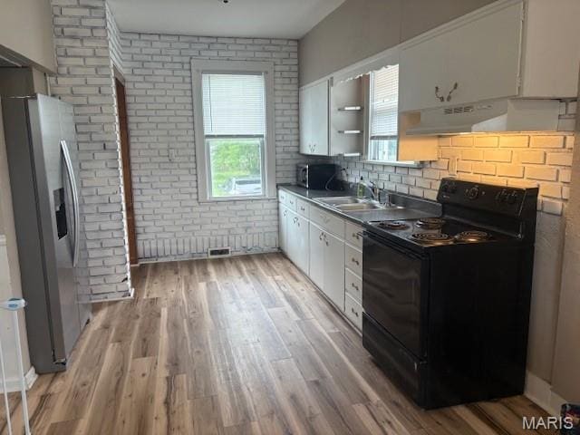 10303 Lincoln Trl, Fairview Heights, IL 62208 - kitchen with appliances with stainless steel finishes, white cabinetry, plenty of natural light, light wood-style floors, and brick wall
