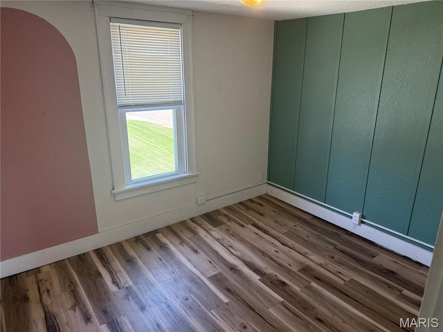 10303 Lincoln Trl, Fairview Heights, IL 62208 - empty room with arched walkways and wood finished floors