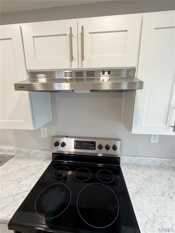 604 N Henderson St Unit A & B, Salem, MO 65560 - kitchen view of stainless steel electric range, wall chimney exhaust hood, white cabinets, and light stone counters