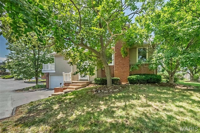 2237 Ole Castle Ct, Chesterfield, MO 63017 - view of property hidden behind natural elements with brick siding, a garage, a front lawn, and asphalt driveway
