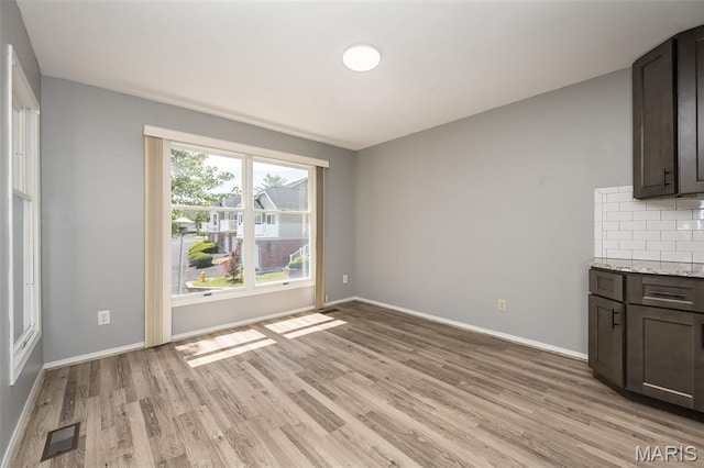 2237 Ole Castle Ct, Chesterfield, MO 63017 - unfurnished dining area with light wood-style flooring and baseboards