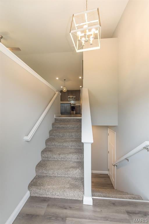 424 Triathlon Dr, Foristell, MO 63348 - stairs with wood finished floors, baseboards, a chandelier, and recessed lighting