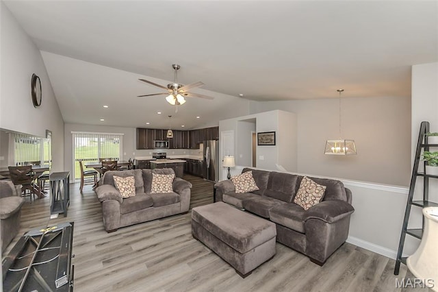 424 Triathlon Dr, Foristell, MO 63348 - living room featuring vaulted ceiling, light wood-type flooring, a chandelier, a ceiling fan, and baseboards