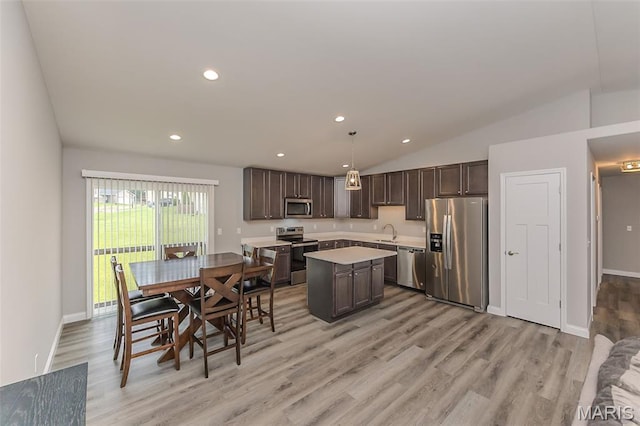 424 Triathlon Dr, Foristell, MO 63348 - kitchen with stainless steel appliances, light countertops, dark brown cabinets, light wood finished floors, and a center island