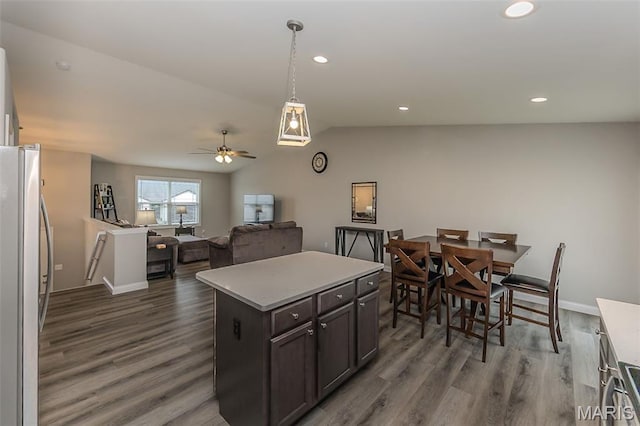 424 Triathlon Dr, Foristell, MO 63348 - kitchen with freestanding refrigerator, wood finished floors, vaulted ceiling, light countertops, and a ceiling fan
